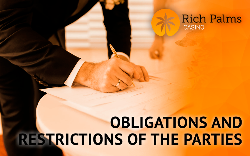 A man in a suit signs documents for Rich Palms Casino